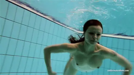 Обнаженная куколка искусно плавает под водой
