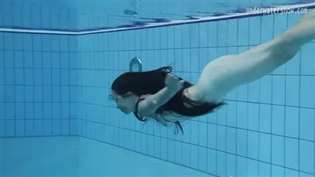 Обнаженная русалочка плавает под водой в бассейне