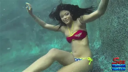 Привлекательная азиатская русалка раздевается под водой и позирует