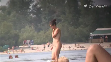 Сексуальная девица с голыми сиськами расслабляется на горячем песочке